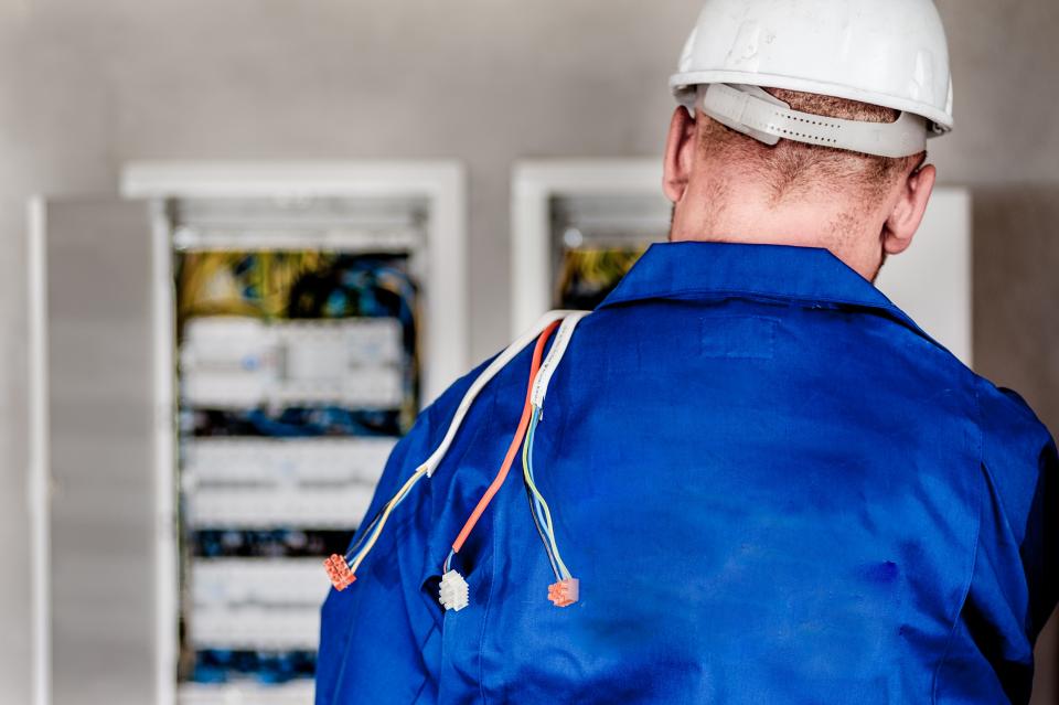 Electrician working inside an electrical distribution panel